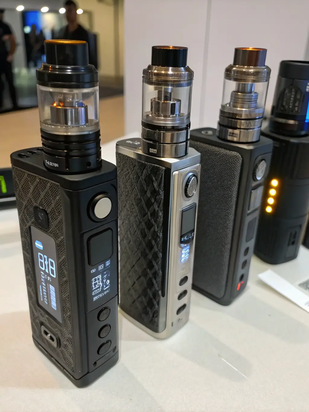 A professional image of vape mods and accessories, including tanks, coils, and batteries, displayed in an organized manner to highlight the range of products.
